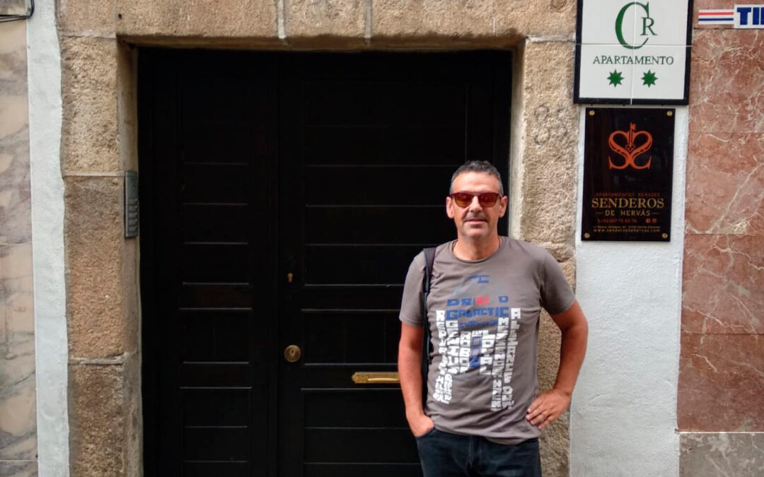 Persona frente a los Apartamentos Rurales Senderos de Hervás en el centro histórico de Hervás.